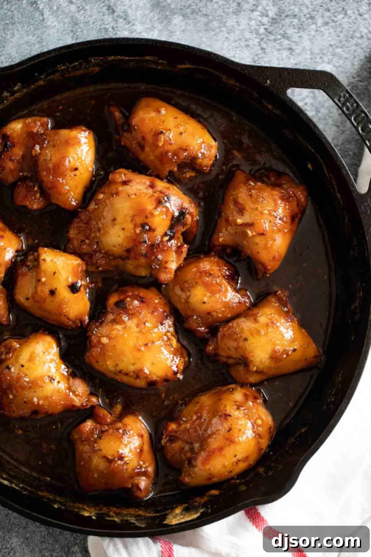 Overhead view of Shoyu Chicken in a cast iron pan, with a dishtowel.