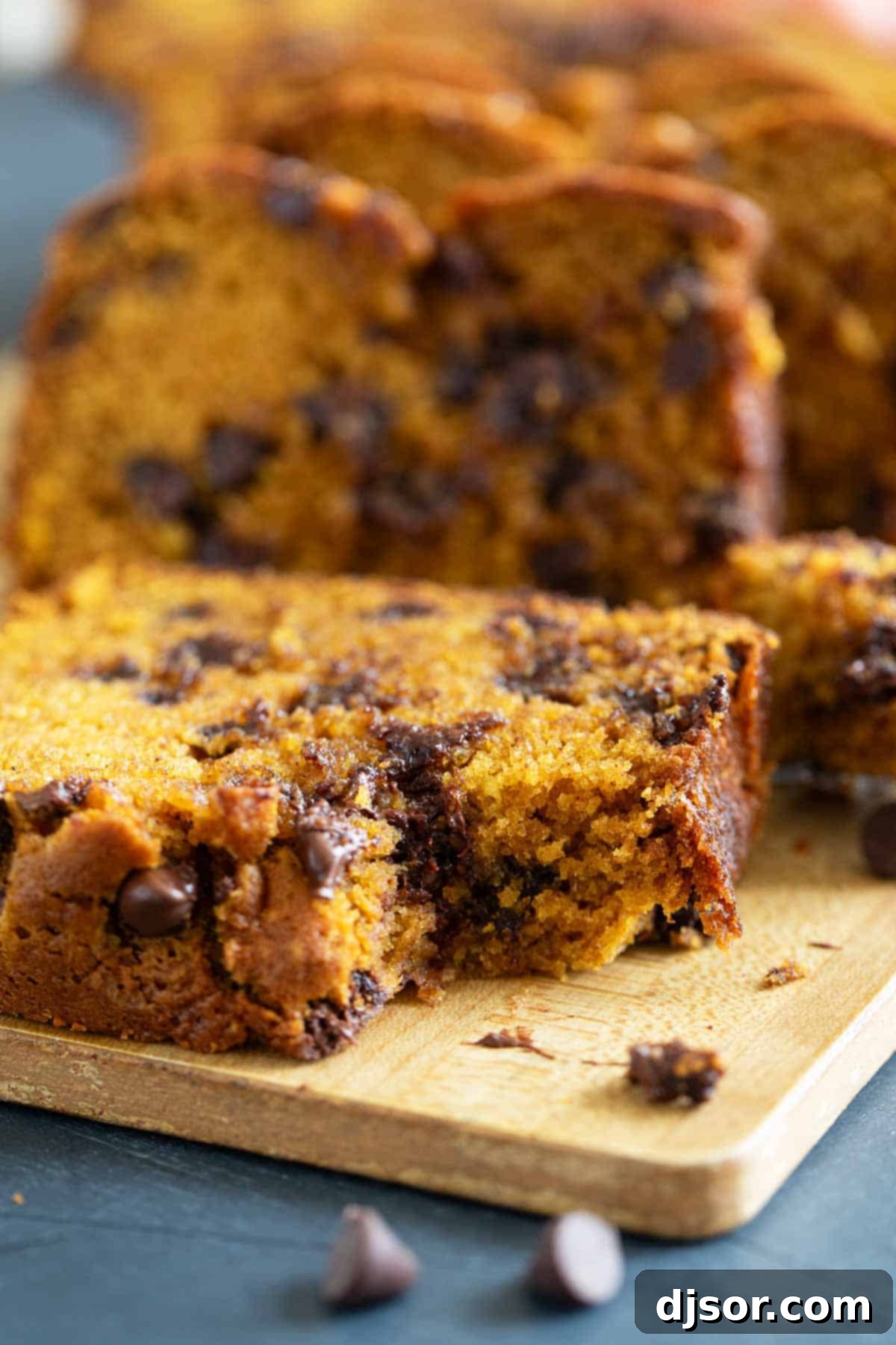 Chocolate Chip Pumpkin Bread 7 A slice of Pumpkin Chocolate Chip Bread with a bite taken out, showcasing its soft, moist crumb and visible chocolate chips.