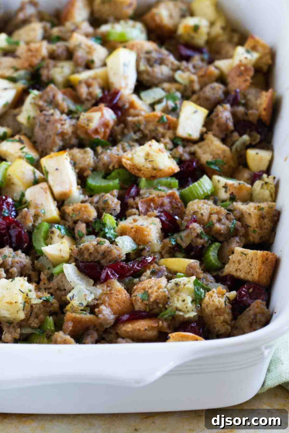 All of the flavors of fall come together in this Sausage Stuffing with Apples and Cranberries for the perfect holiday stuffing recipe. A golden casserole dish of savory Sausage Stuffing with Apples and Cranberries, perfectly baked and ready for the holiday table.