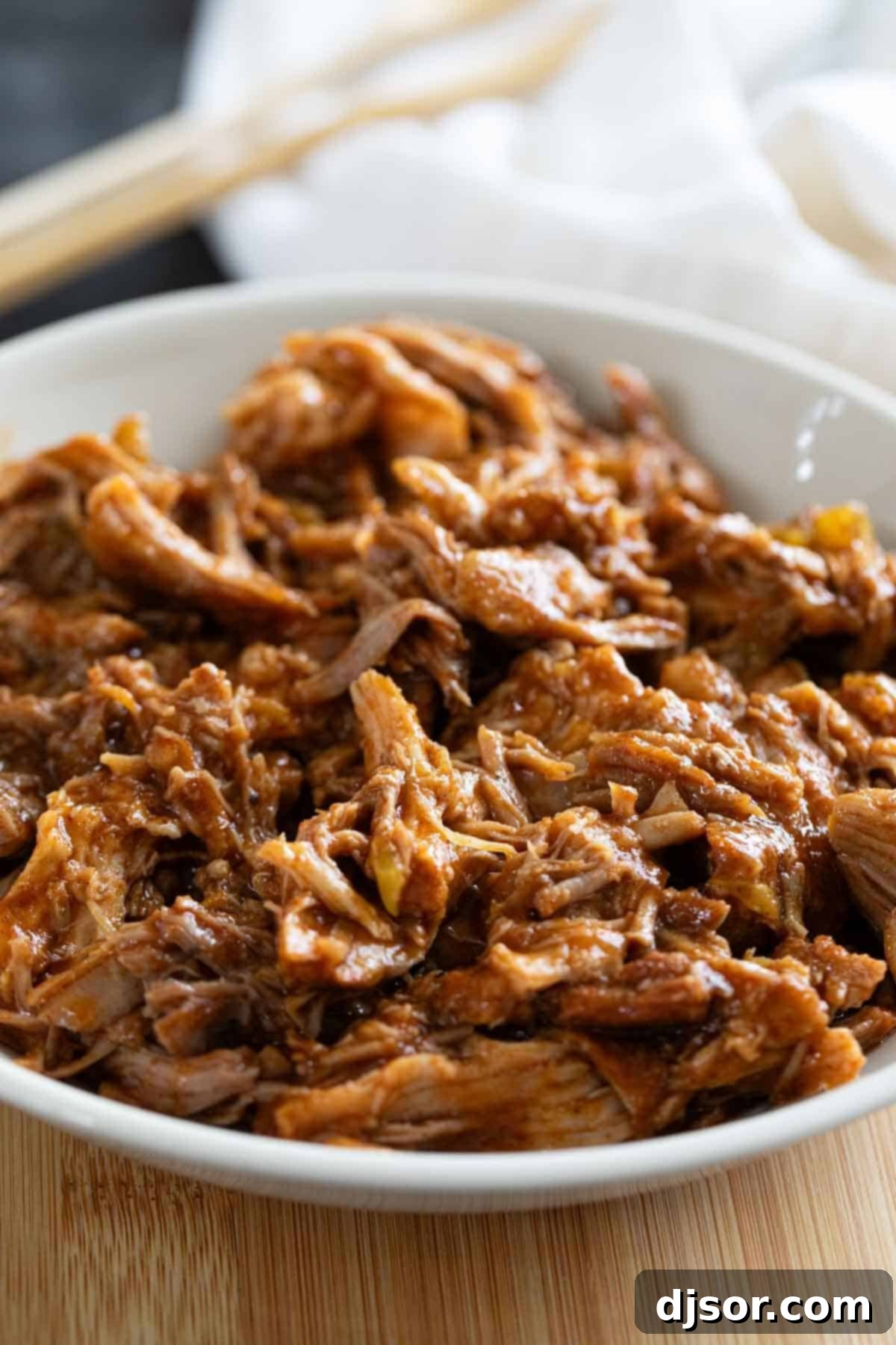 Bowl with Cafe Rio Sweet Pork on a cutting board.
