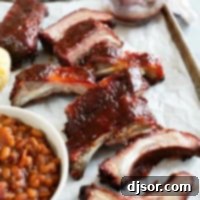 Slow-Smoked Ribs 9 Smoked ribs on a tray with baked beans and corn muffins.