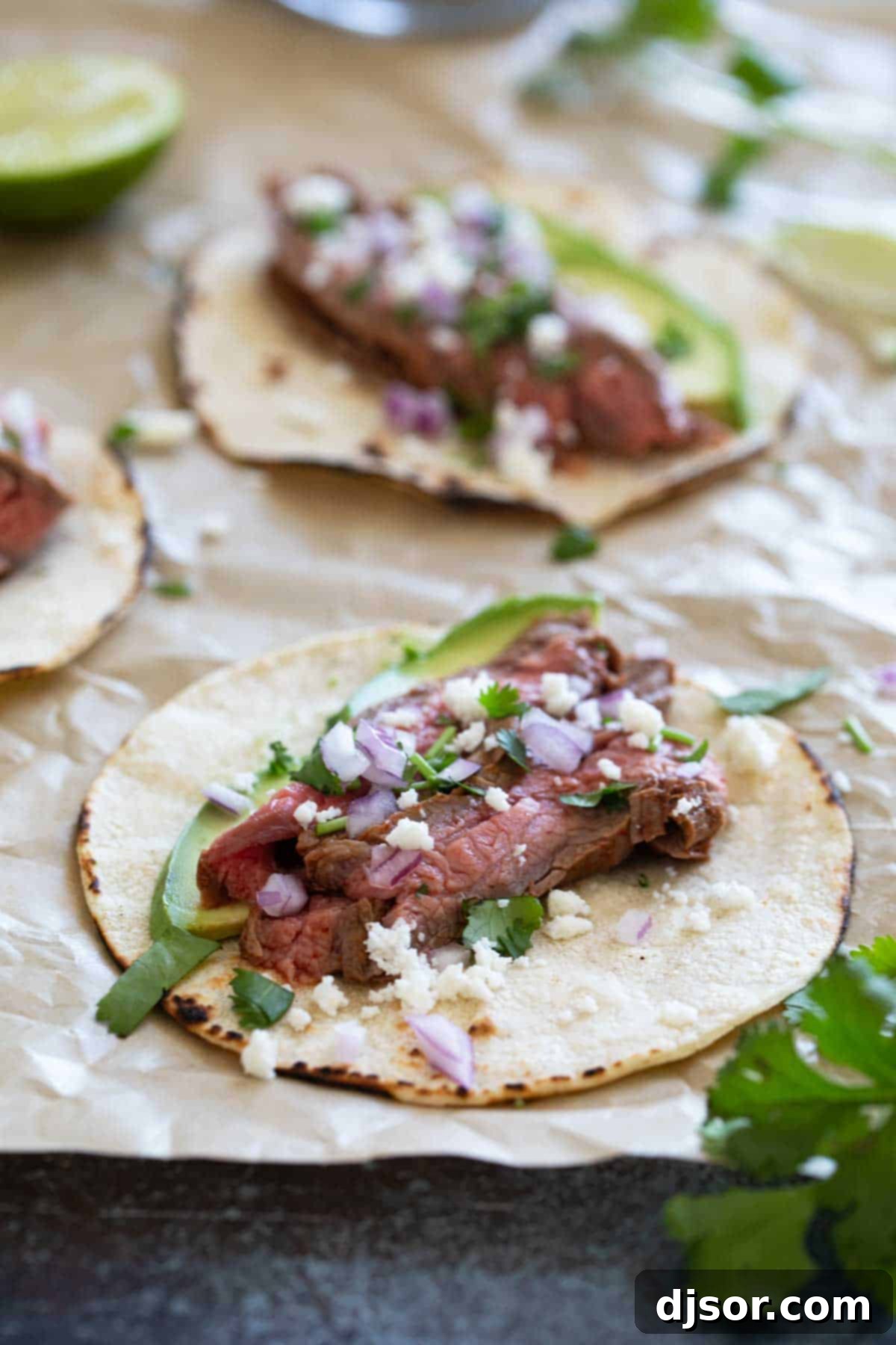 Street Style Flank Steak Tacos 6 Fully assembled Flank Steak Tacos garnished with avocado, fresh cilantro, red onions, and queso fresco.