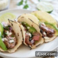 Street Style Flank Steak Tacos 8 Flank Steak Tacos on corn tortillas on a plate.