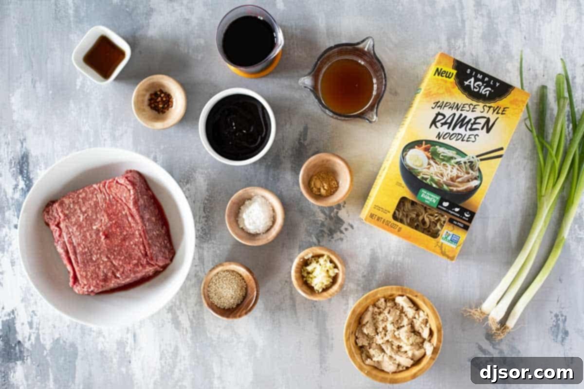 A collection of fresh ingredients laid out on a kitchen counter, including ground beef, ramen noodles, soy sauce, hoisin, ginger, garlic, and green onions, essential for making Mongolian Ground Beef Noodles.