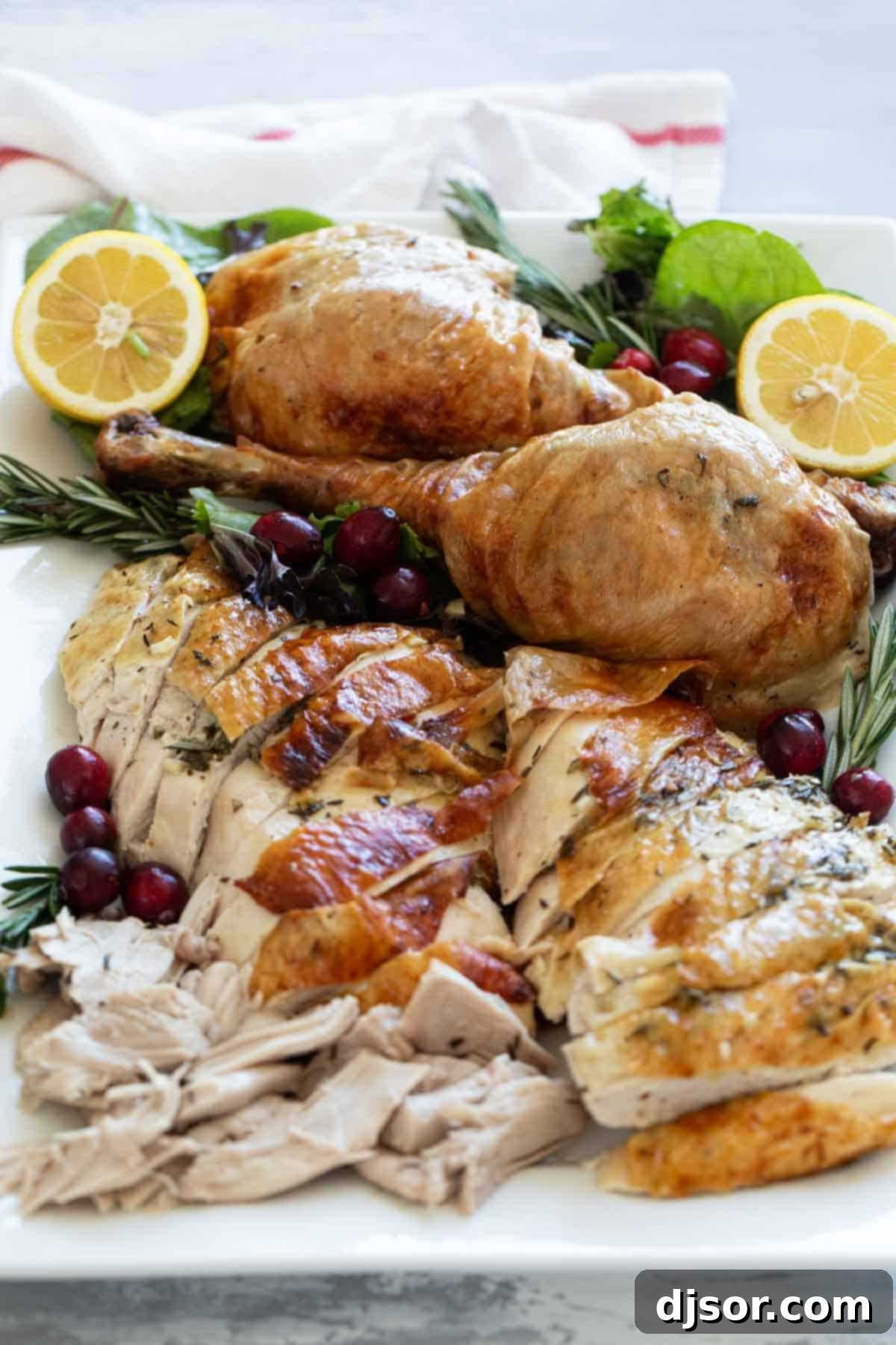 The Ultimate Roast Turkey 8 Perfectly carved slices of moist roast turkey, arranged beautifully on a white serving dish, garnished with fresh herbs, ready to be served.