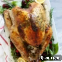 The Ultimate Roast Turkey 10 A perfectly roasted whole turkey, golden brown and garnished with fresh herbs, resting on a rustic wooden serving platter, ready for carving.