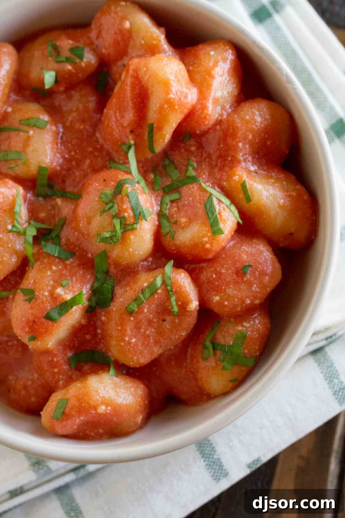 Overhead view of a serving bowl filled with creamy Ricotta Gnocchi and Tomato Sauce, ready to be enjoyed.