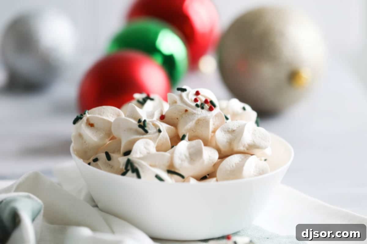 bowl filled with meringue cookies with Christmas ornaments in the background