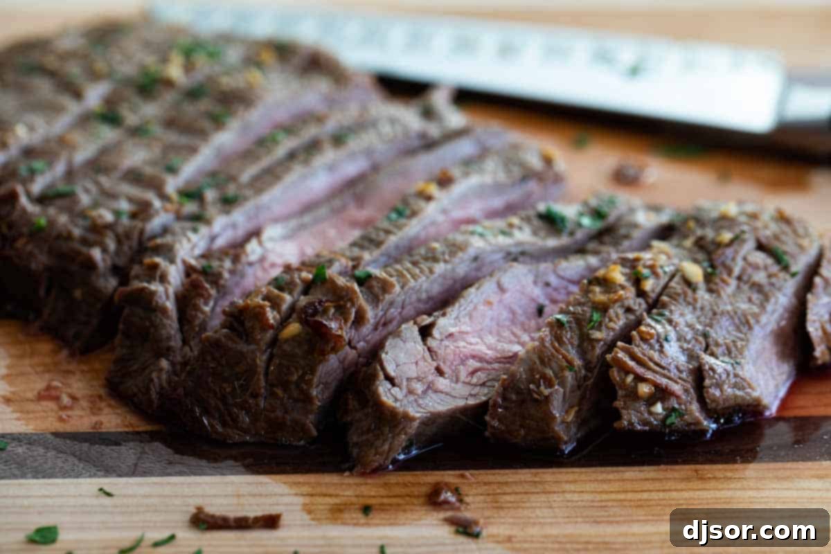 Sliced flank steak served on a cutting board, showcasing its tender texture.