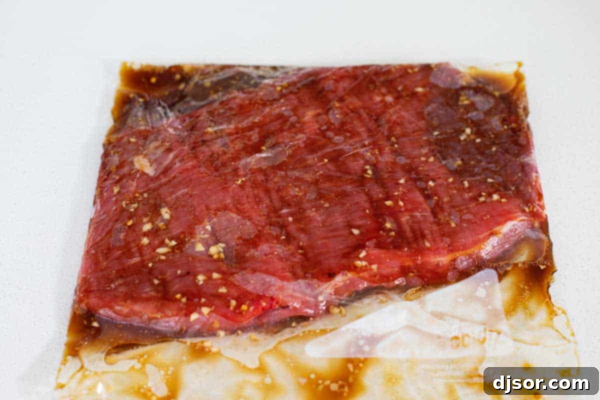 Flank steak marinating in a ziplock bag with the flavorful mixture.