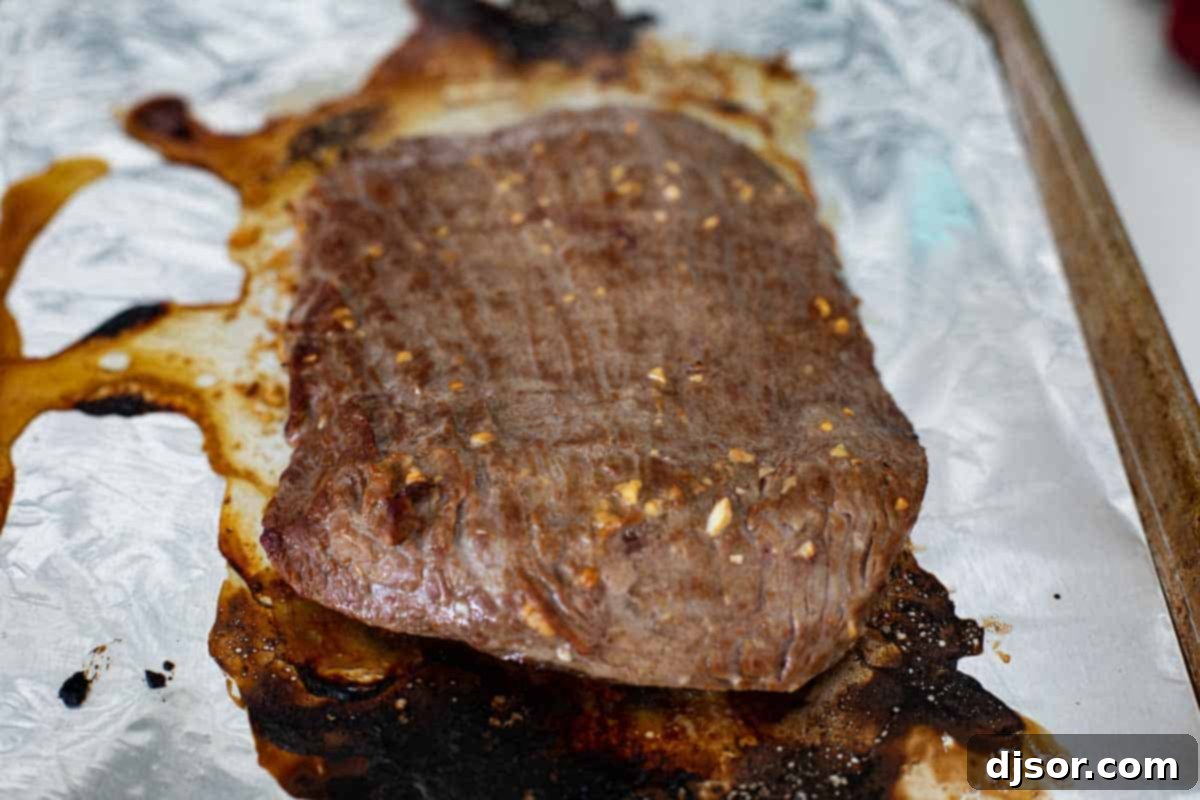 Perfectly cooked flank steak, golden brown and ready to be sliced.
