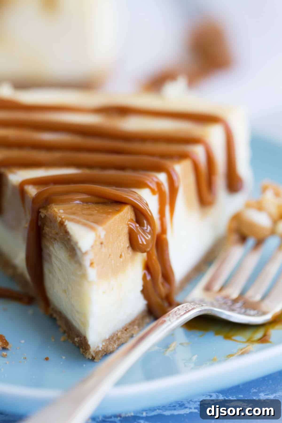 A beautiful slice of Dulce de Leche Cheesecake, drizzled generously with extra caramel, ready to be enjoyed.