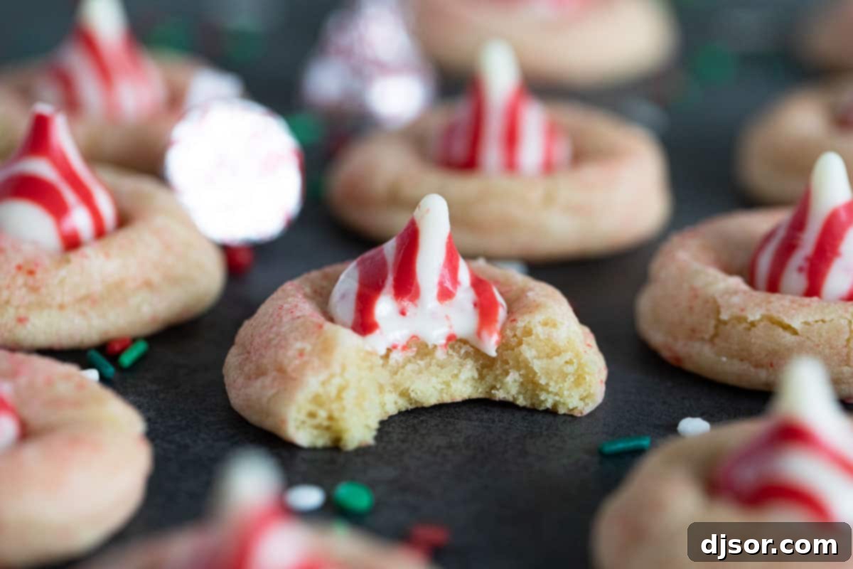 Peppermint Kiss Cookie topped with a peppermint kiss, with a bite taken, revealing the soft interior.