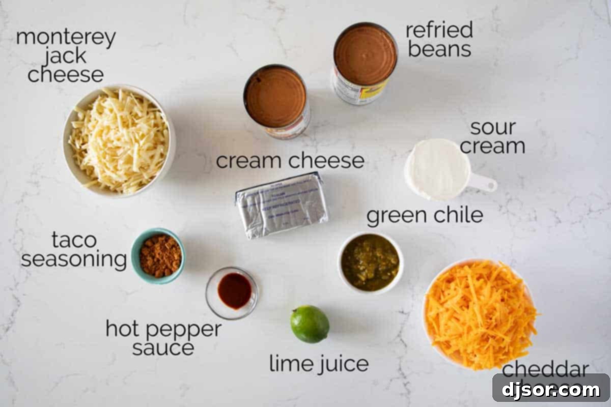 Key Ingredients for the Best Bean Dip A selection of fresh ingredients laid out for making bean dip, including cream cheese, sour cream, refried beans, chiles, and cheese.