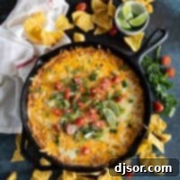 Fiesta Bean Dip 2 cast iron skillet with bean dip topped with tomatoes and cilantro