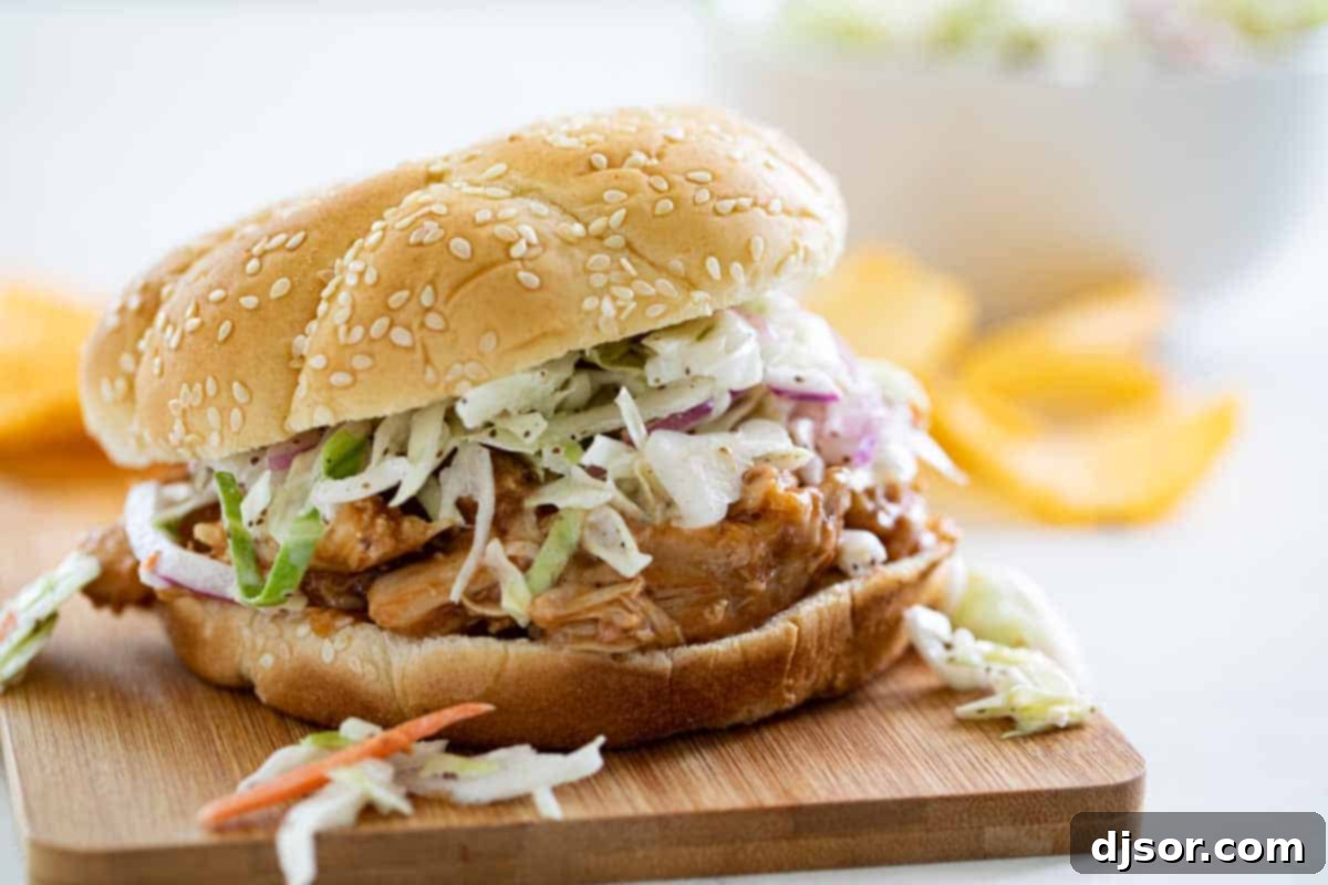 Teriyaki Chicken Sandwich topped with coleslaw on a cutting board, showcasing the vibrant colors and appealing texture of the dish.