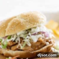 Slow Cooker Teriyaki Chicken Sandwich on a cutting board, garnished with fresh herbs and a vibrant coleslaw side.
