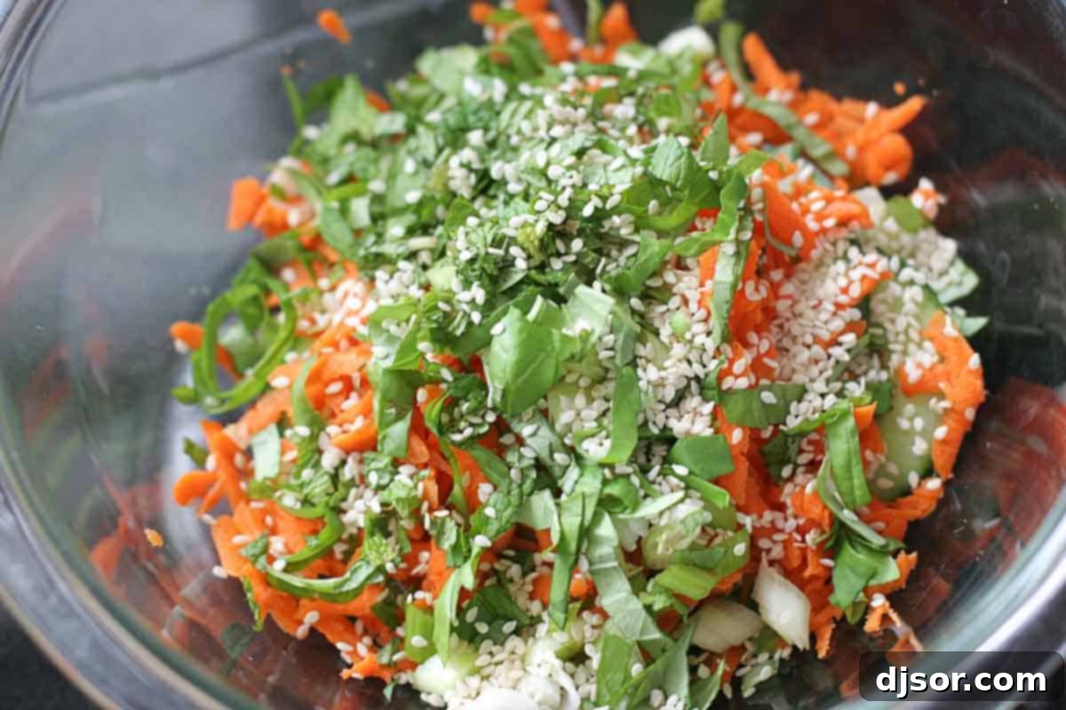 Fresh vegetable mixture for Thai chicken wraps including shredded carrots, cucumber, and green onions