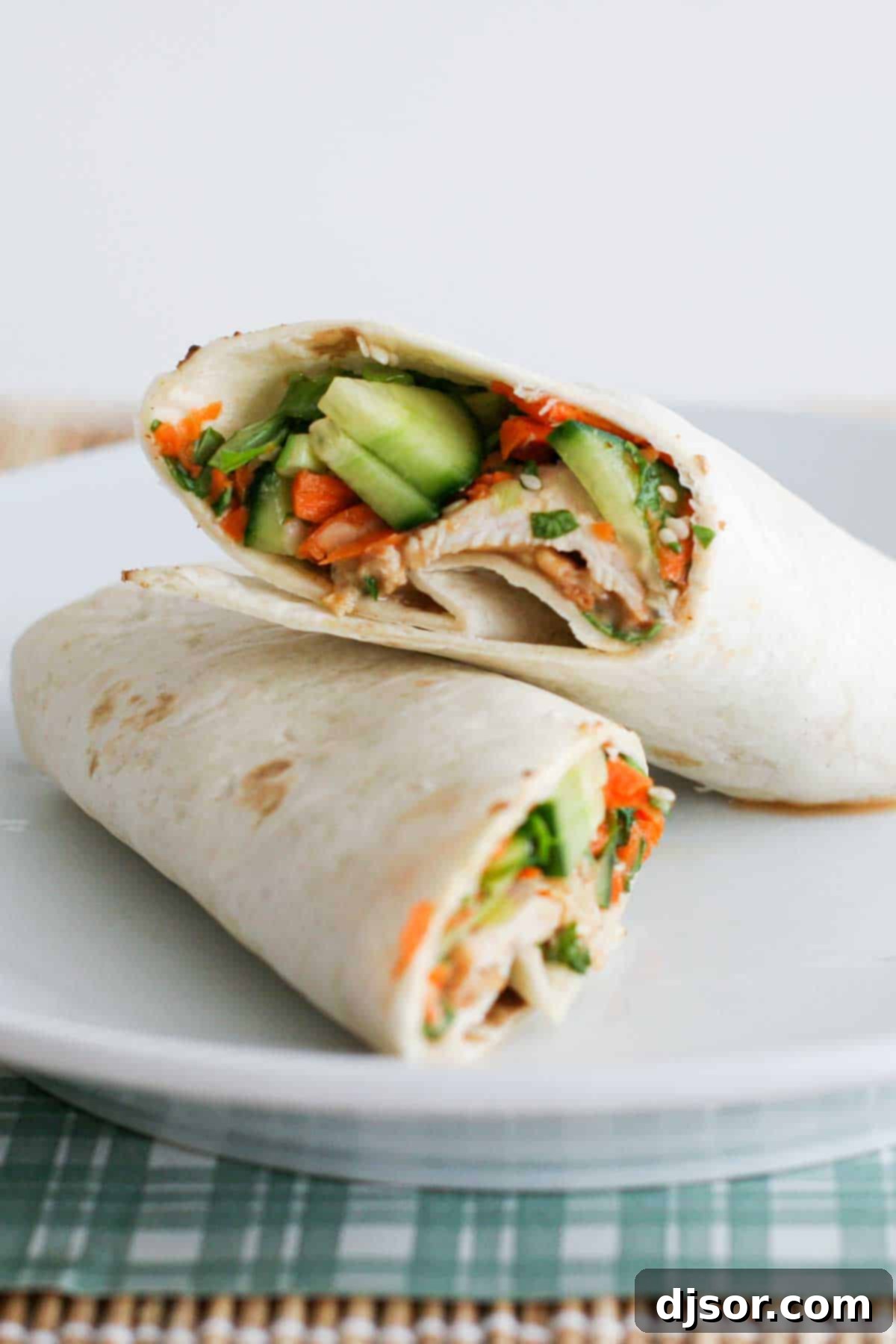 Thai Chicken Wrap, cut in half and elegantly stacked on a plate, revealing its colorful filling