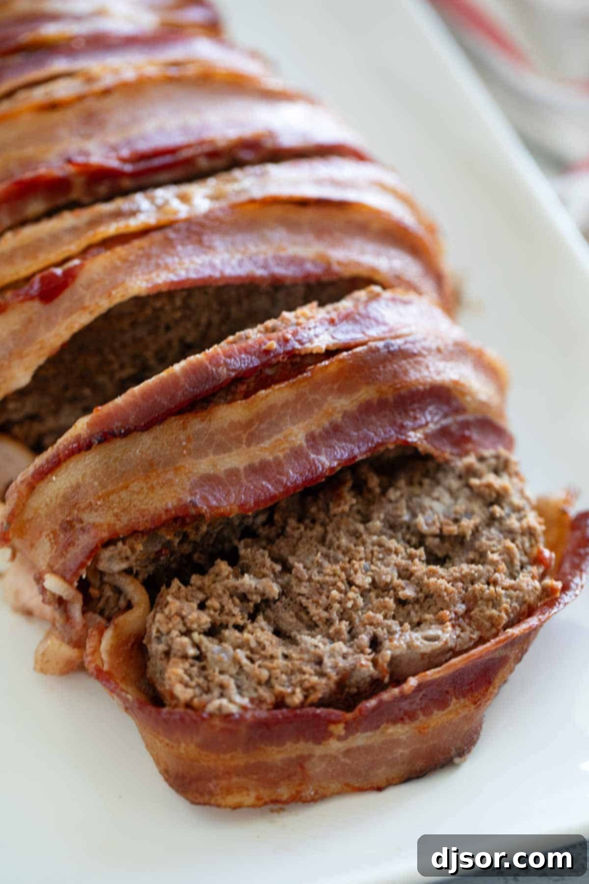 The Ultimate Bacon Meatloaf 7 Bacon Wrapped Meatloaf cut into slices.