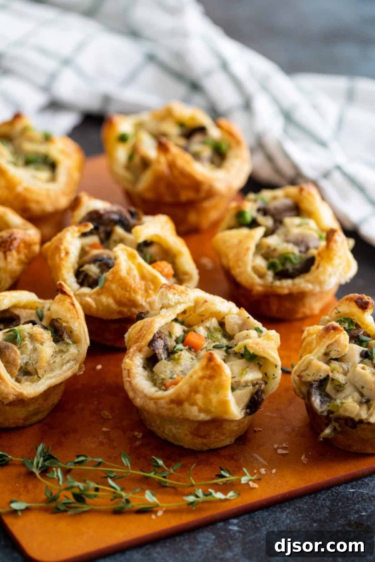 Mini Chicken Pot Pies on a cutting board, showcasing their golden-brown puff pastry crusts.