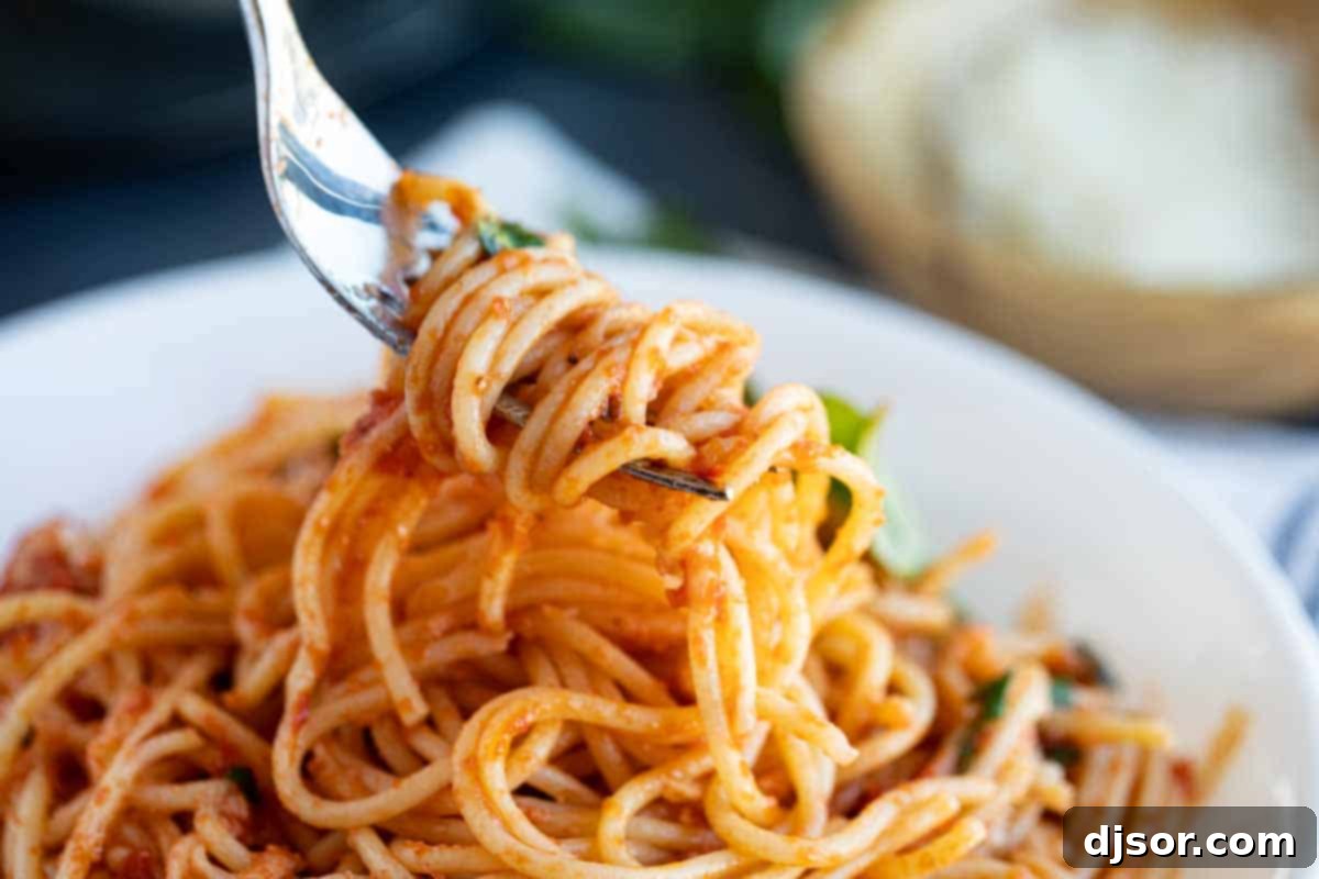 A single fork twirling a delicate portion of garlic spaghetti, highlighting the texture and appeal of the dish.