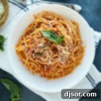 garlic spaghetti topped with parmesan and fresh basil
