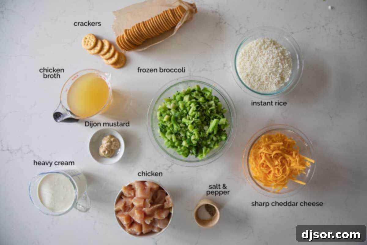 Various fresh ingredients laid out on a white surface, including chicken breasts, heavy cream, chicken broth, Dijon mustard, instant rice, frozen broccoli, sharp cheddar cheese, and Ritz crackers, ready for making Chicken Divan.