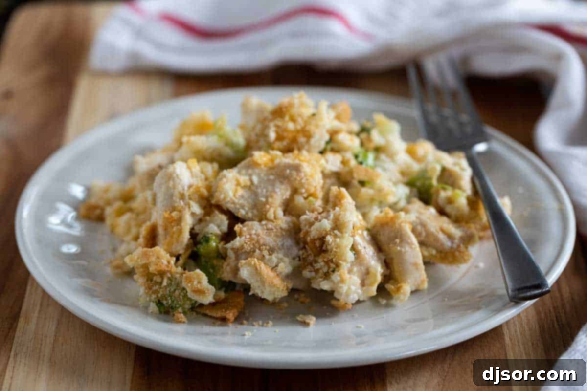 A plate with a generous serving of Chicken Divan, showcasing the creamy sauce, chicken pieces, broccoli florets, and crispy cracker topping.