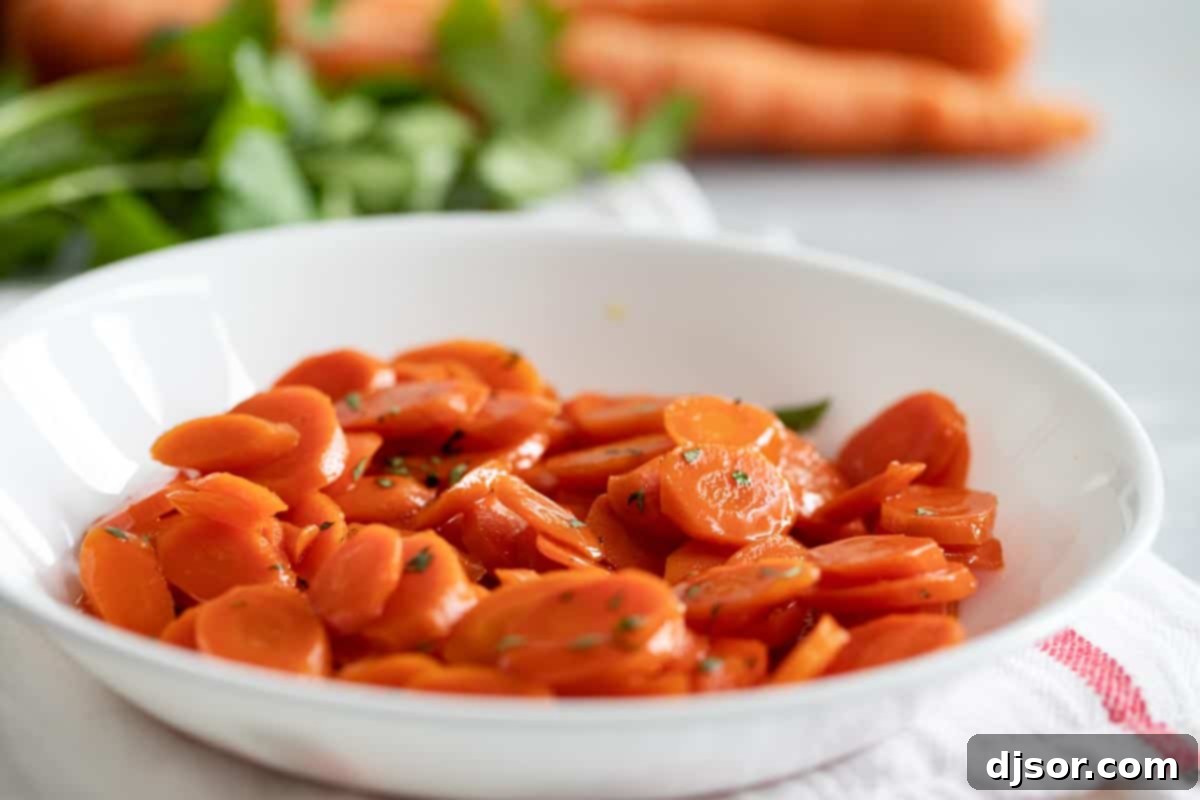 These Glazed Carrots are a simple side dish that add a bit of wow to your dinner. Cooked on the stovetop in a simple sugar and butter glaze, this carrot recipe will become a go-to! bowl with glazed carrots with parsley sprinkled on top