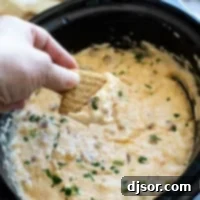 Dipping a cracker into Slow Cooker Reuben Dip.