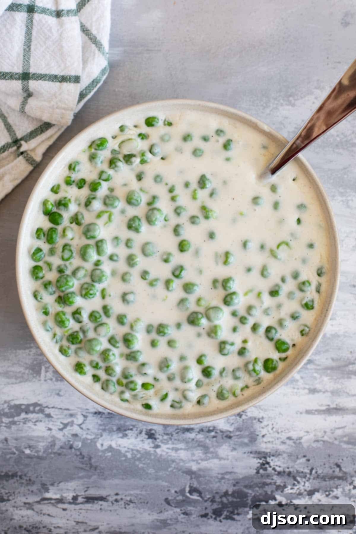 Serving bowl filled with Creamed Peas.