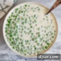 Serving bowl filled with Creamed Peas.